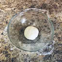 Plastic-covered dough ready for resting